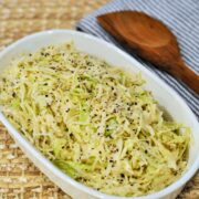 angel hair coleslaw in white bowl with wood spoon in background