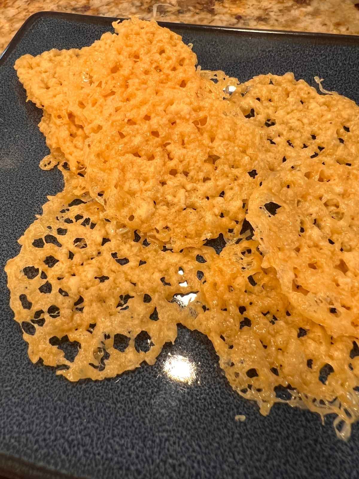 Blue plate with asiago cheese crisps.