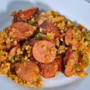 sausage, cauliflower rice, and diced bell pepper on white plate