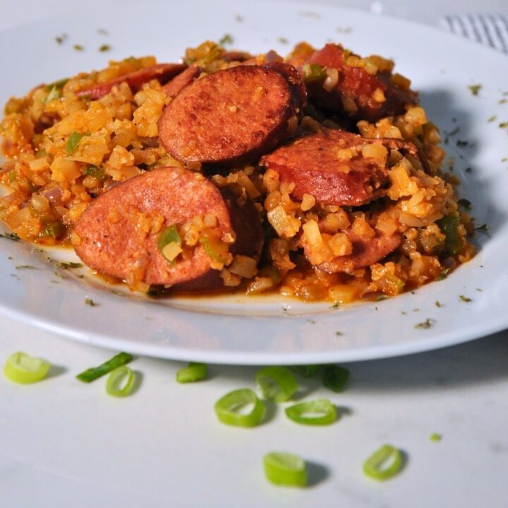 sausage, cauliflower rice, and diced bell pepper on white plate