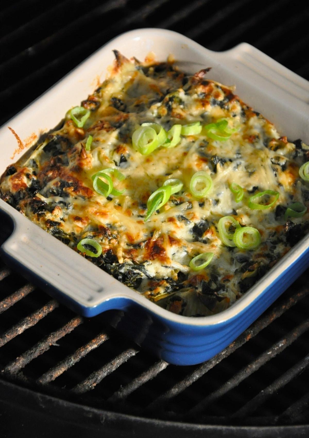 smoked spinach artichoke dip in baking dish on smoker