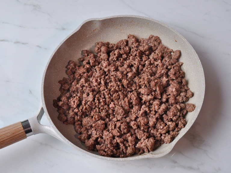 cooked ground beef in a pan sitting on countertop