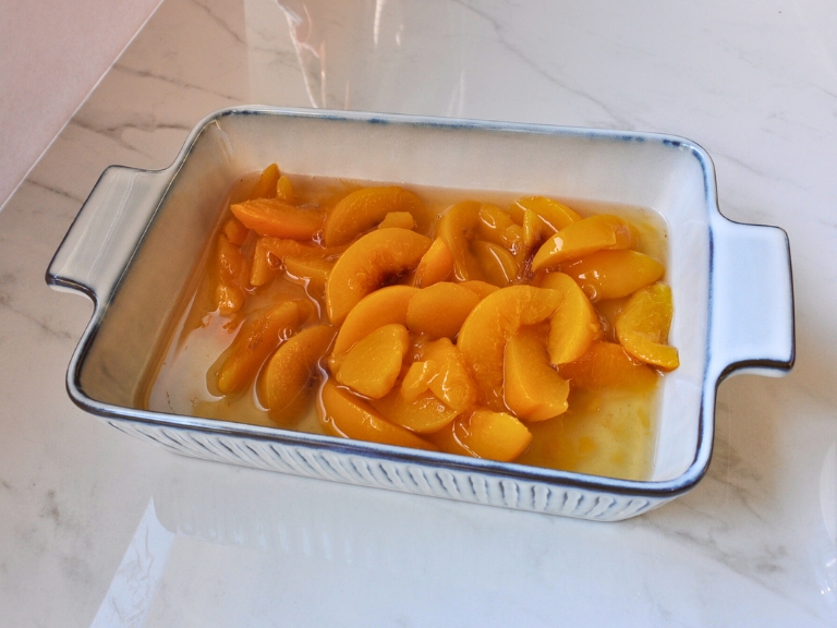 canned peaches in blue and white baking dish on countertop